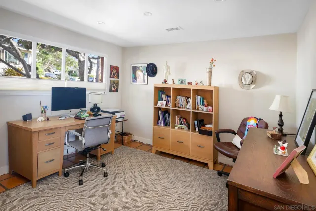 a view of a workspace with furniture and a window