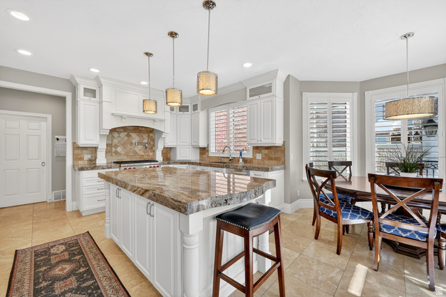 714 Draper Heights Way Draper, UT 84020 - Photo 13 of 88 Kitchen with white cabinets, glass fronted cabinets, a kitchen breakfast bar, and a center island