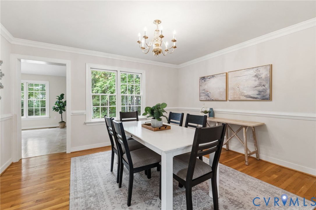 2615 Salisbury Road Midlothian, VA 23113 - Photo 7 of 36 a view of a dining room with furniture a chandelier and wooden floor