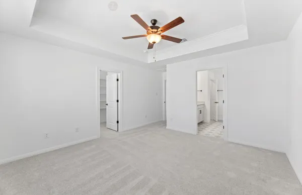 an empty room with fan and windows