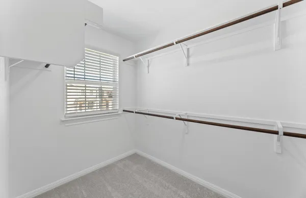 an empty room with closet and ceiling fan