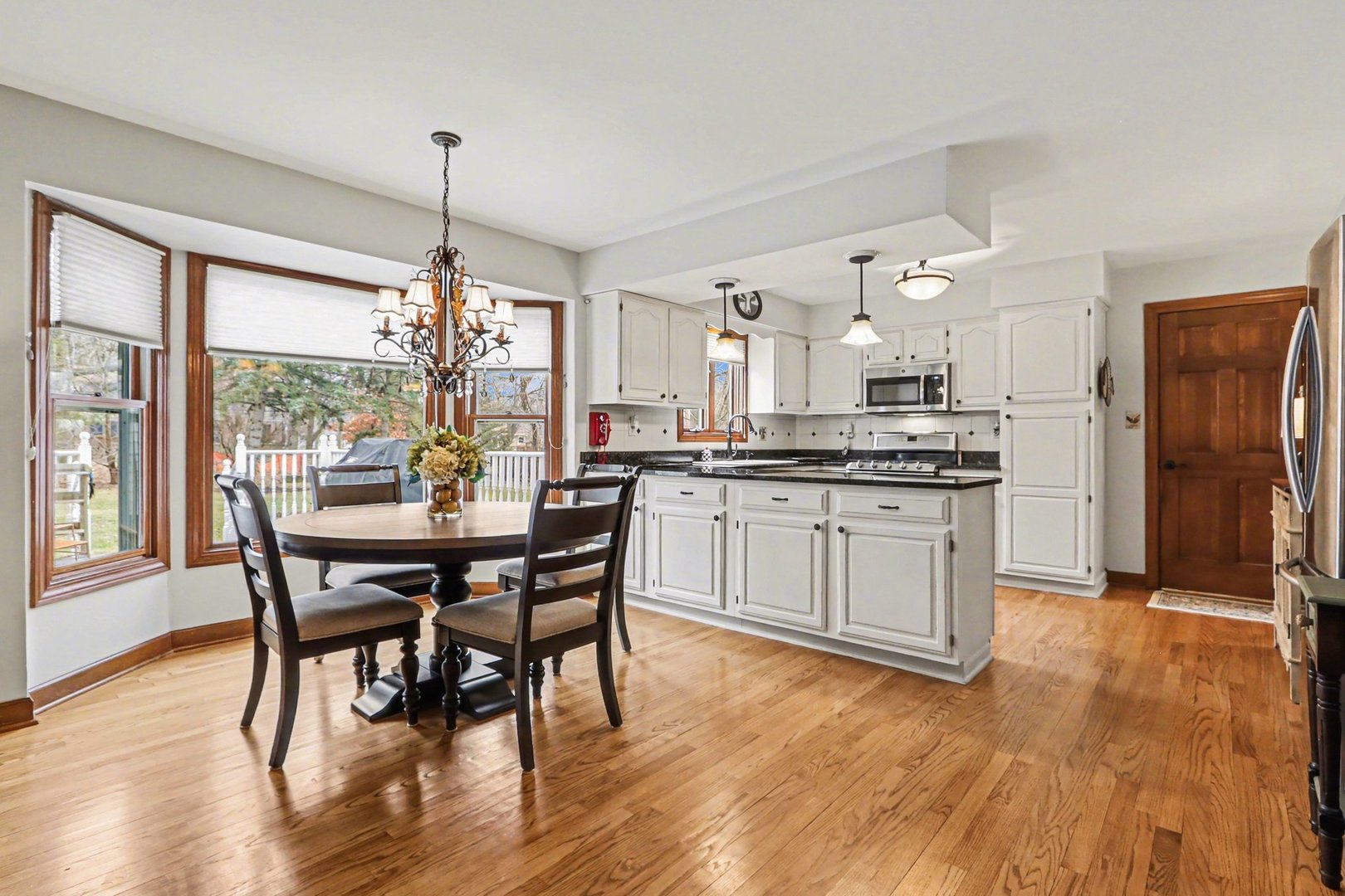 570 Violet Lane Batavia, IL 60510 - Photo 12 of 28 a kitchen with stainless steel appliances granite countertop a stove a refrigerator a kitchen island a dining table and chairs with wooden floor