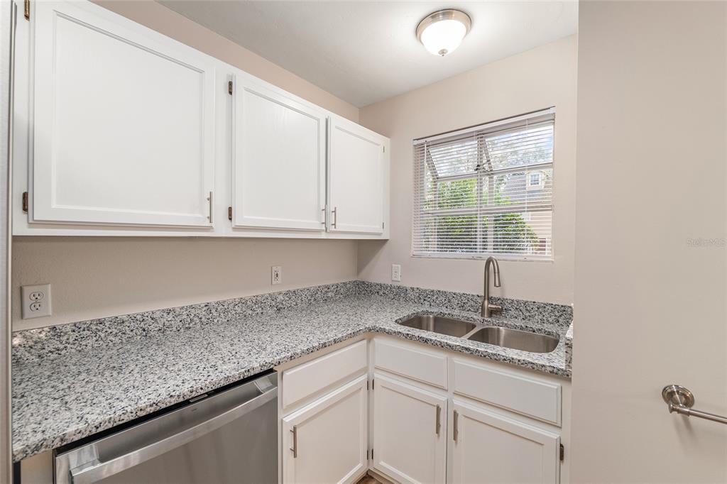 9755 Southwest 52nd Road Gainesville, FL 32608 - Photo 11 of 43 a kitchen with granite countertop white cabinets and window