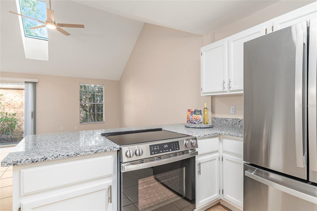 9755 Southwest 52nd Road Gainesville, FL 32608 - Photo 13 of 43 a kitchen with granite countertop a sink stove and refrigerator