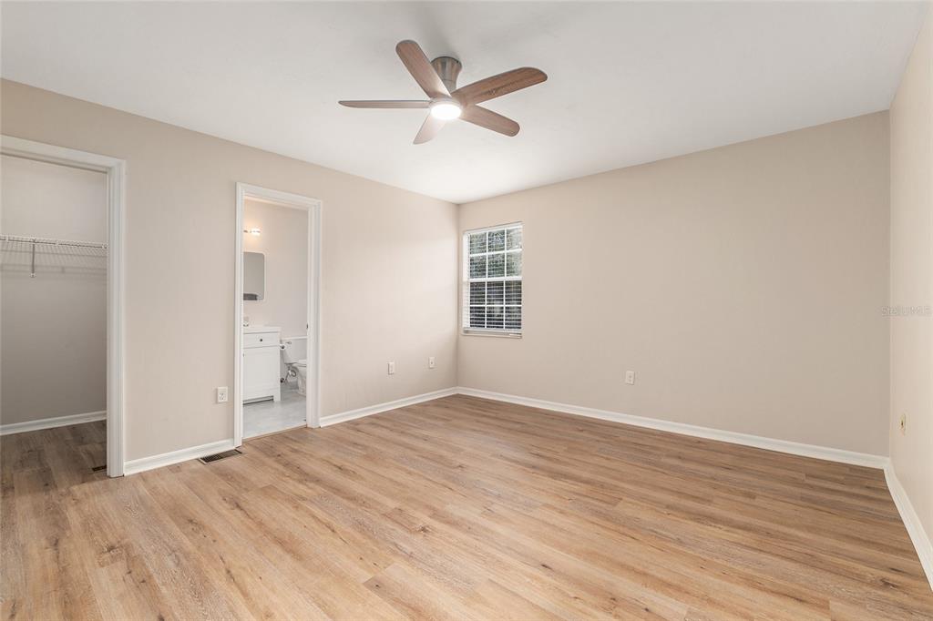 9755 Southwest 52nd Road Gainesville, FL 32608 - Photo 26 of 43 an empty room with wooden floor and ceiling fan
