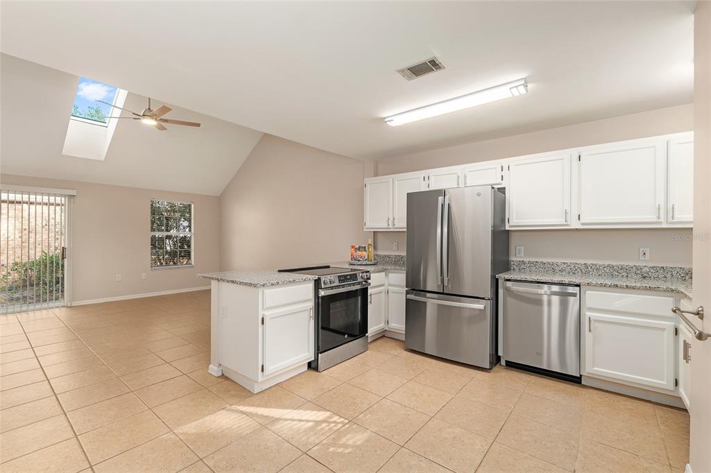 9755 Southwest 52nd Road Gainesville, FL 32608 - Photo 7 of 43 a kitchen with stainless steel appliances granite countertop a refrigerator and a stove top oven