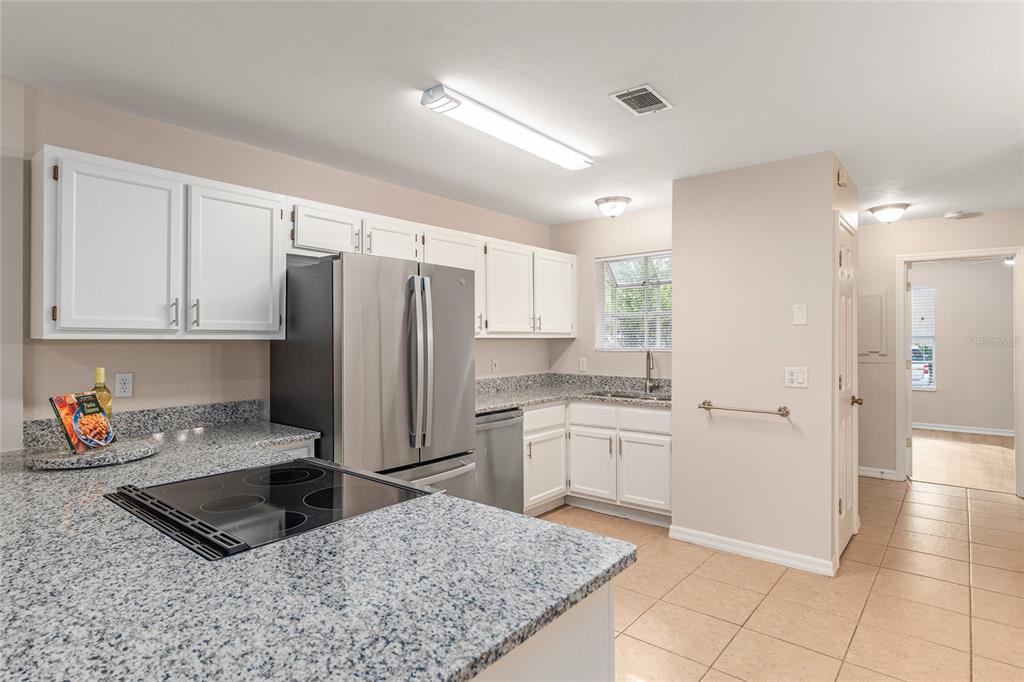 9755 Southwest 52nd Road Gainesville, FL 32608 - Photo 8 of 43 a kitchen with stainless steel appliances granite countertop a refrigerator sink and cabinets