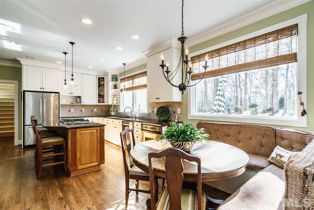 7116 North Ridge Drive Raleigh, NC 27615 - Photo 8 of 25 a kitchen with stainless steel appliances granite countertop a stove a refrigerator a kitchen island with a stove and white cabinets