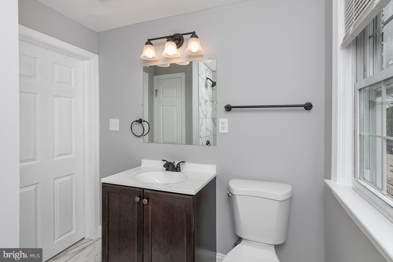 1901 Crestview Road Baltimore, MD 21239 - Photo 16 of 30 a bathroom with a toilet sink and mirror