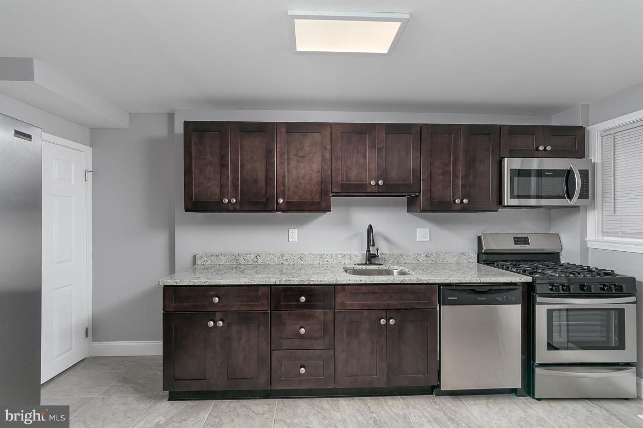 1901 Crestview Road Baltimore, MD 21239 - Photo 10 of 30 a kitchen with granite countertop stainless steel appliances a stove a sink a refrigerator a microwave and cabinets