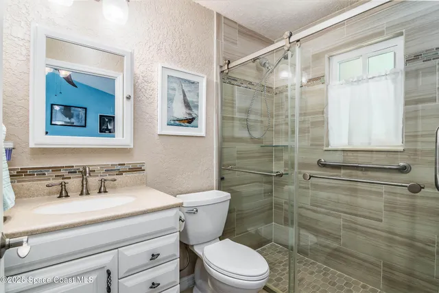 a bathroom with a sink mirror toilet and shower
