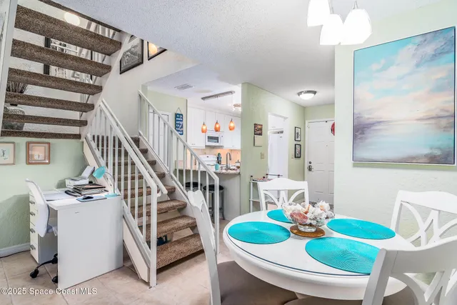 a view of a dining room with furniture a chandelier and wooden floor