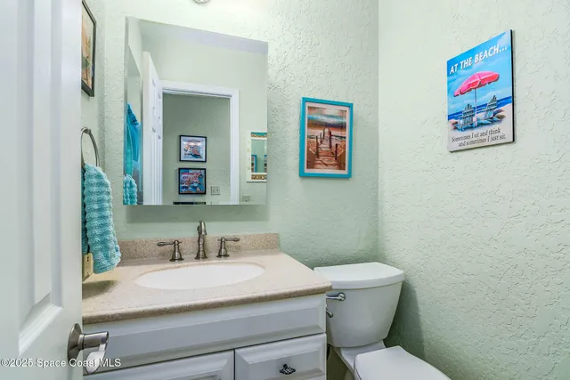 a bathroom with a granite countertop toilet sink and mirror