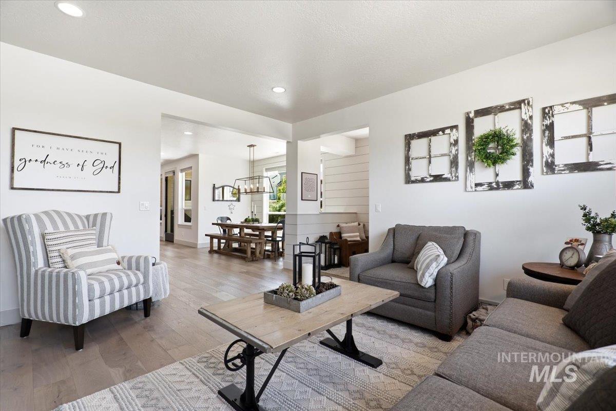 3794 South Single Tree Avenue Boise, ID 83716 - Photo 13 of 50 Open-concept living space featuring wood-finish flooring, recessed lighting, and white walls