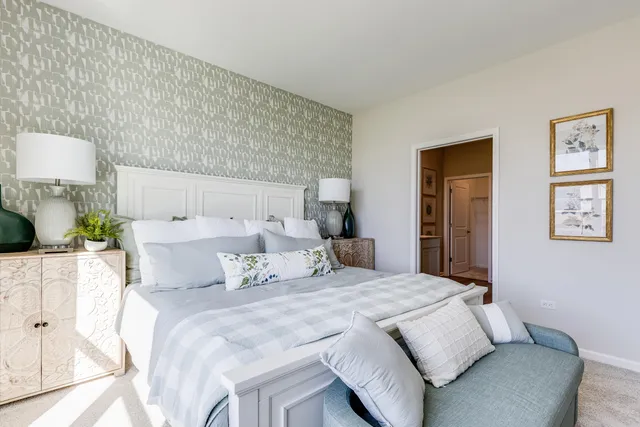 a bedroom with a bed a lamp and a large window