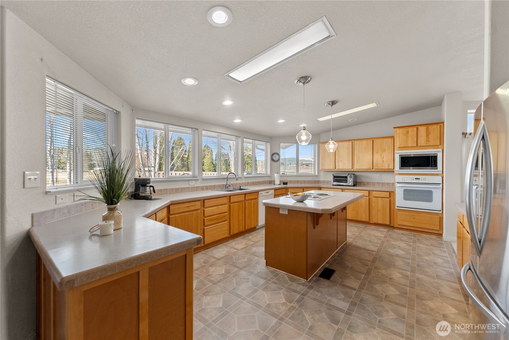 95 Woods Road Omak, WA 98841 - Photo 13 of 40 a large kitchen with kitchen island a sink a counter top space and stainless steel appliances