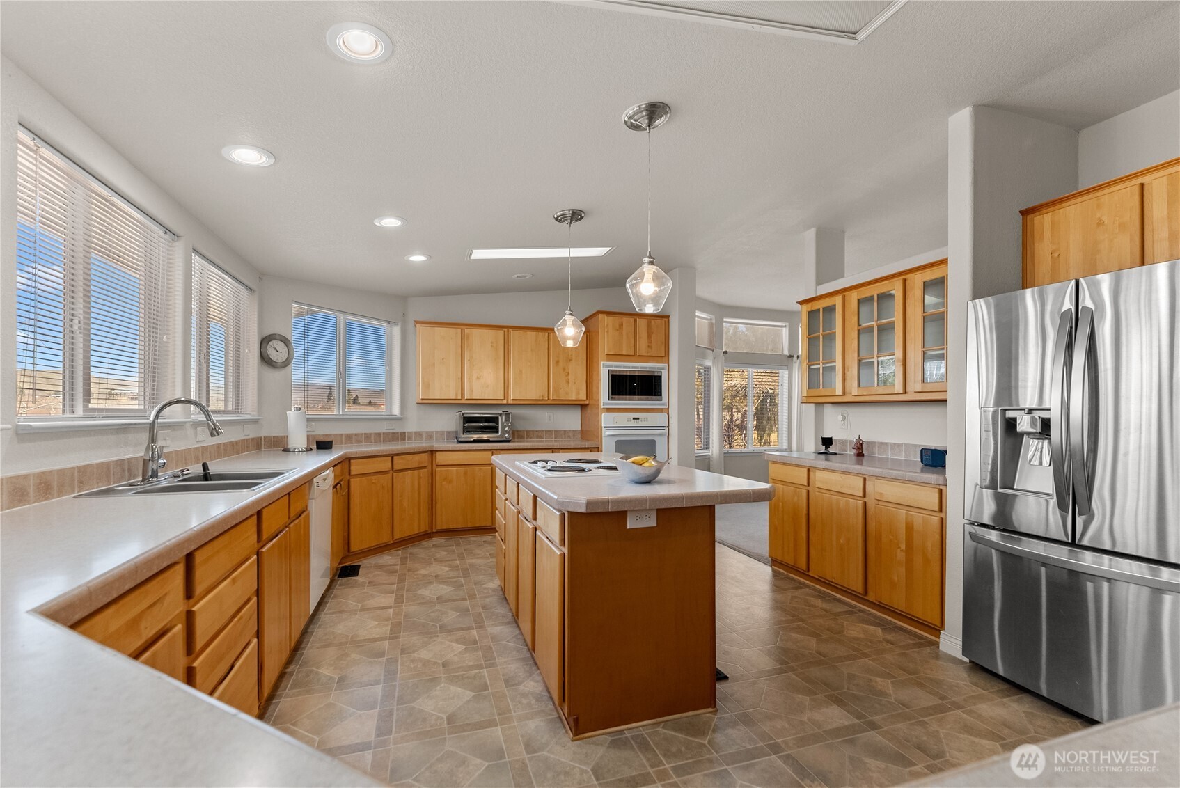 95 Woods Road Omak, WA 98841 - Photo 15 of 40 a kitchen with stainless steel appliances granite countertop a sink counter space cabinets and a large window