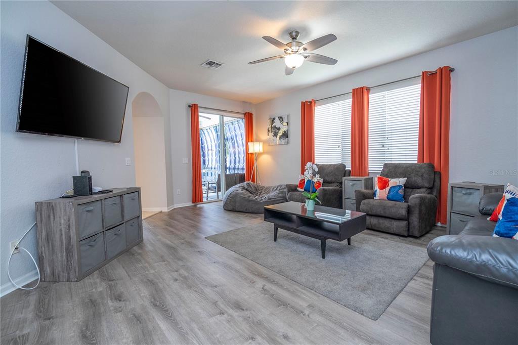 4978 Strand Street Kissimmee, FL 34758 - Photo 7 of 30 a living room with furniture and a flat screen tv