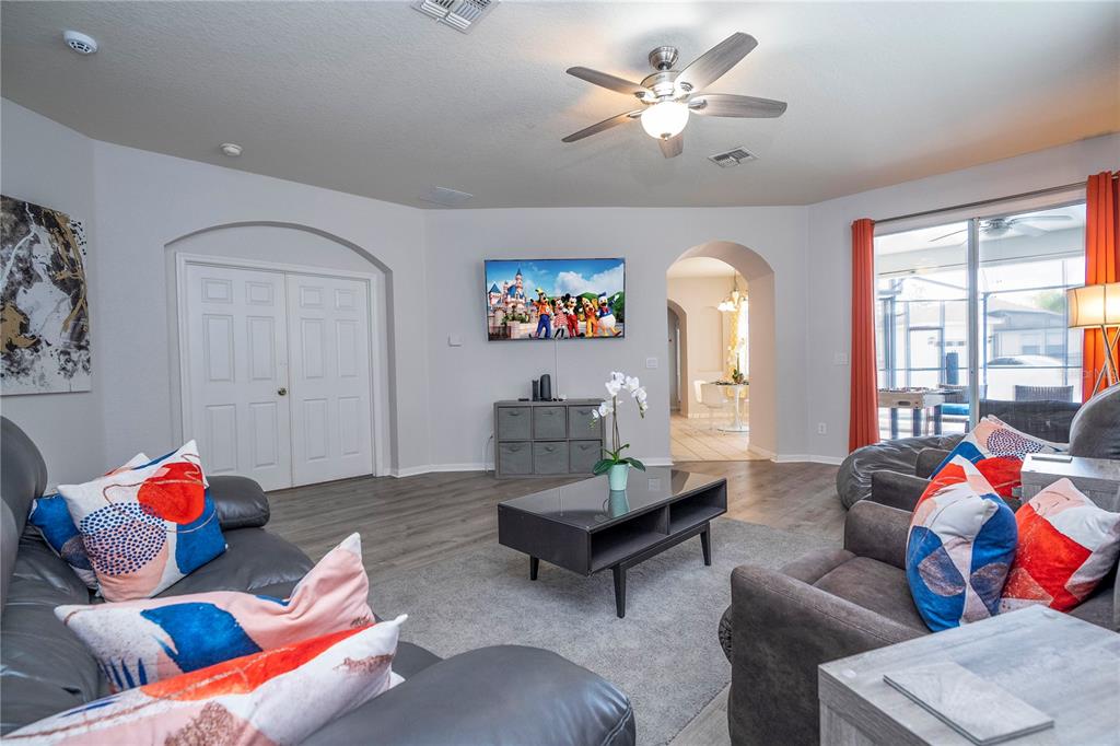 4978 Strand Street Kissimmee, FL 34758 - Photo 8 of 30 a living room with furniture ceiling fan and a window