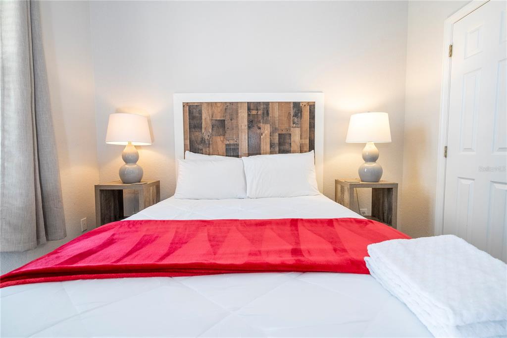 4978 Strand Street Kissimmee, FL 34758 - Photo 10 of 30 a bedroom with a large bed and a lamp