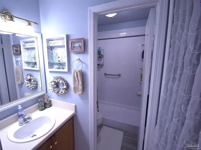 a bathroom with a sink vanity granite tub shower and a mirror