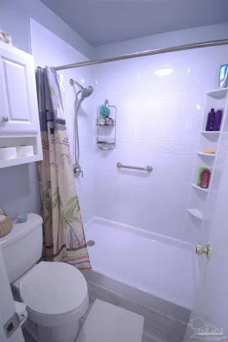 a white toilet sitting next to a bath tub