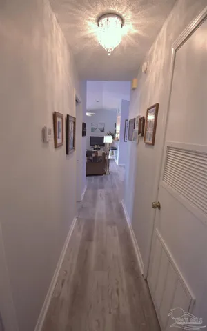 a view of a hallway to a livingroom and a window