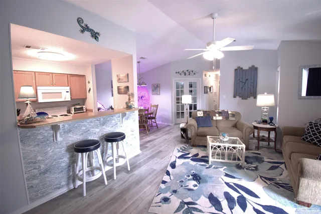 a living room with lots of furniture and kitchen view