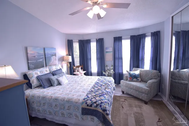 a bedroom with a bed and ceiling fan