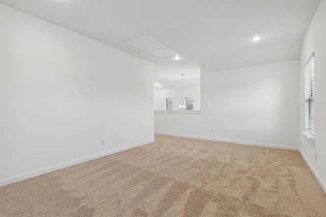 an empty room with cabinet and windows