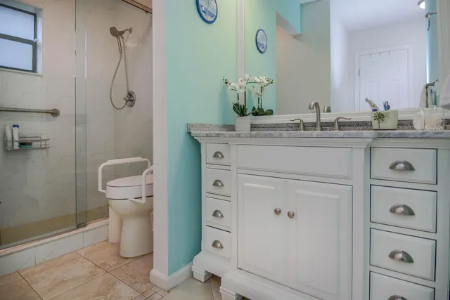a bathroom with a granite countertop toilet sink and mirror
