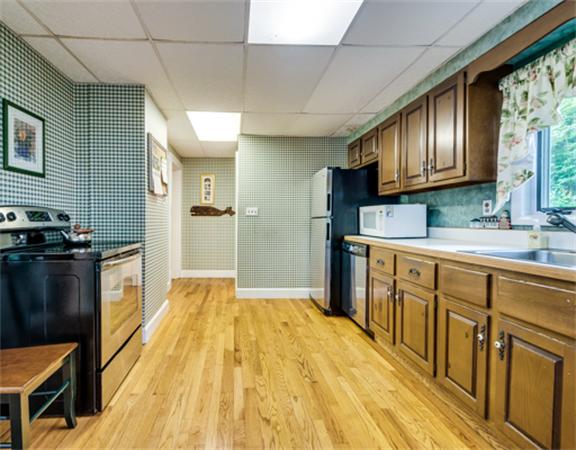 96 Columbia Road Arlington, MA 02474 - Photo 11 of 21 a kitchen with granite countertop wooden cabinets a sink a stove and a refrigerator