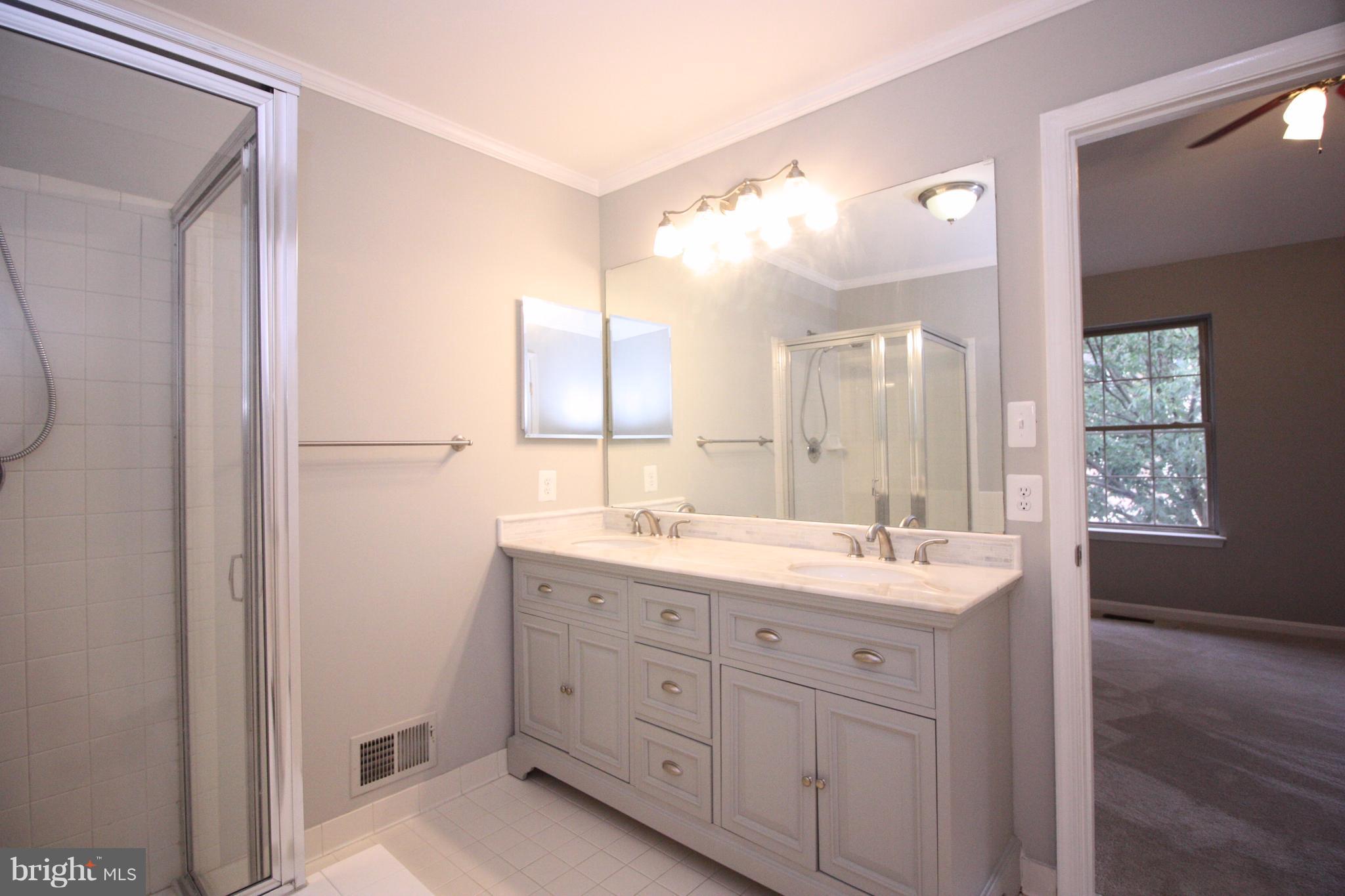 2218 Bear Den Road Frederick, MD 21701 - Photo 16 of 30 a spacious bathroom with a double vanity sink a large mirror a bathtub and
