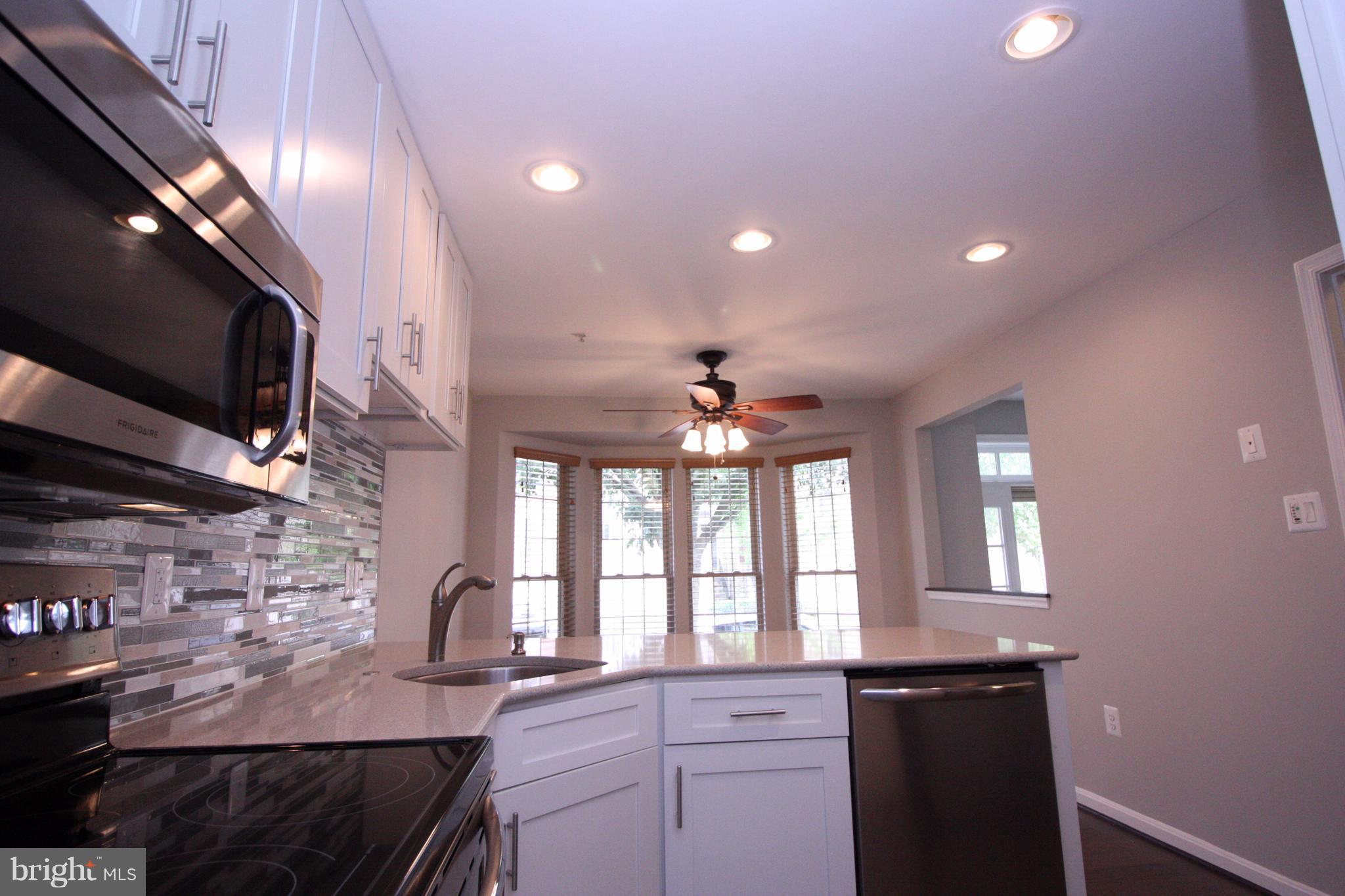 2218 Bear Den Road Frederick, MD 21701 - Photo 5 of 30 a kitchen with stainless steel appliances kitchen island granite countertop a stove a sink and a microwave