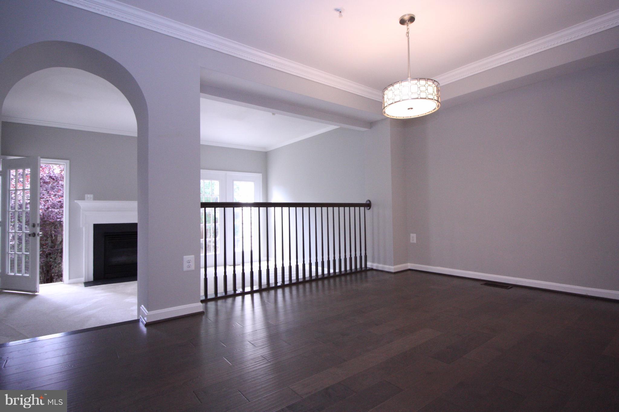 2218 Bear Den Road Frederick, MD 21701 - Photo 7 of 30 an empty room with wooden floor chandelier and windows