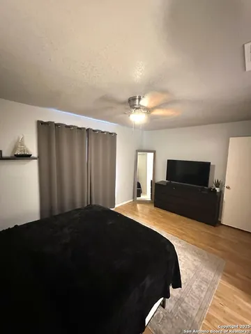 a bedroom with a bed and a flat tv screen on dresser