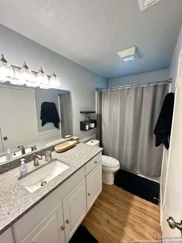 a bathroom with a granite countertop sink toilet and shower
