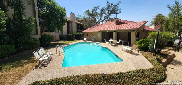 a view of a patio with chairs and table under an umbrella