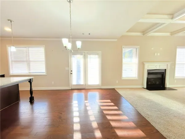 a view of an empty room with window and wooden floor