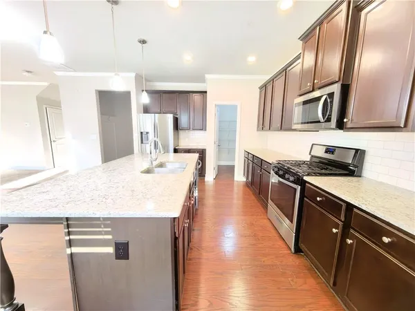 a kitchen with stainless steel appliances granite countertop a sink stove and refrigerator