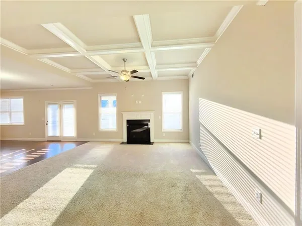 a view of an empty room with a fireplace and a window