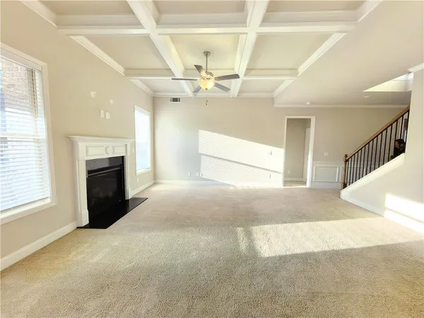 a view of an empty room with a fireplace and a window