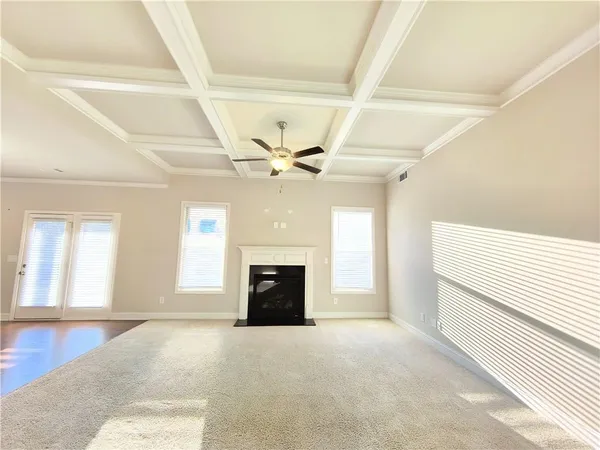 a view of an empty room with a fireplace and a window