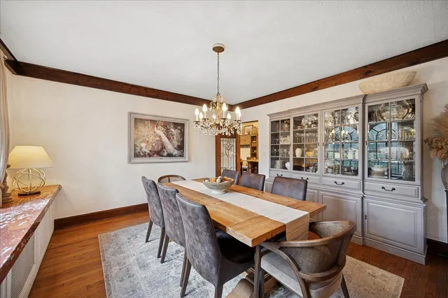 a dining room with furniture a chandelier and wooden floor