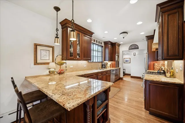 a kitchen with granite countertop a stove a sink a dining table and chairs