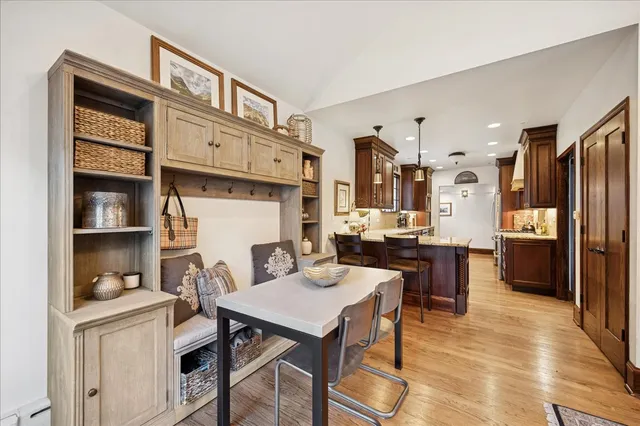 a kitchen with a table chairs refrigerator and cabinets