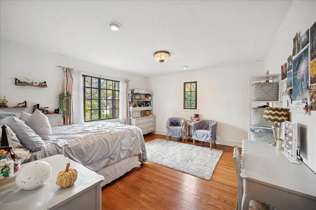 a bedroom with a bed and wooden floor