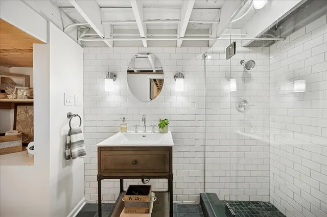 a bathroom with a sink a mirror and a shower