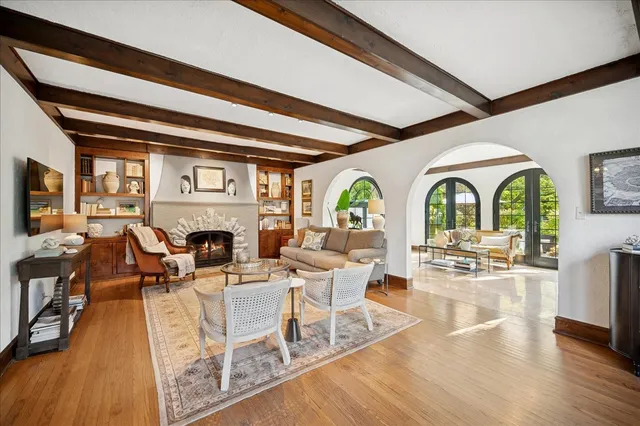 a living room with fireplace furniture and a large window