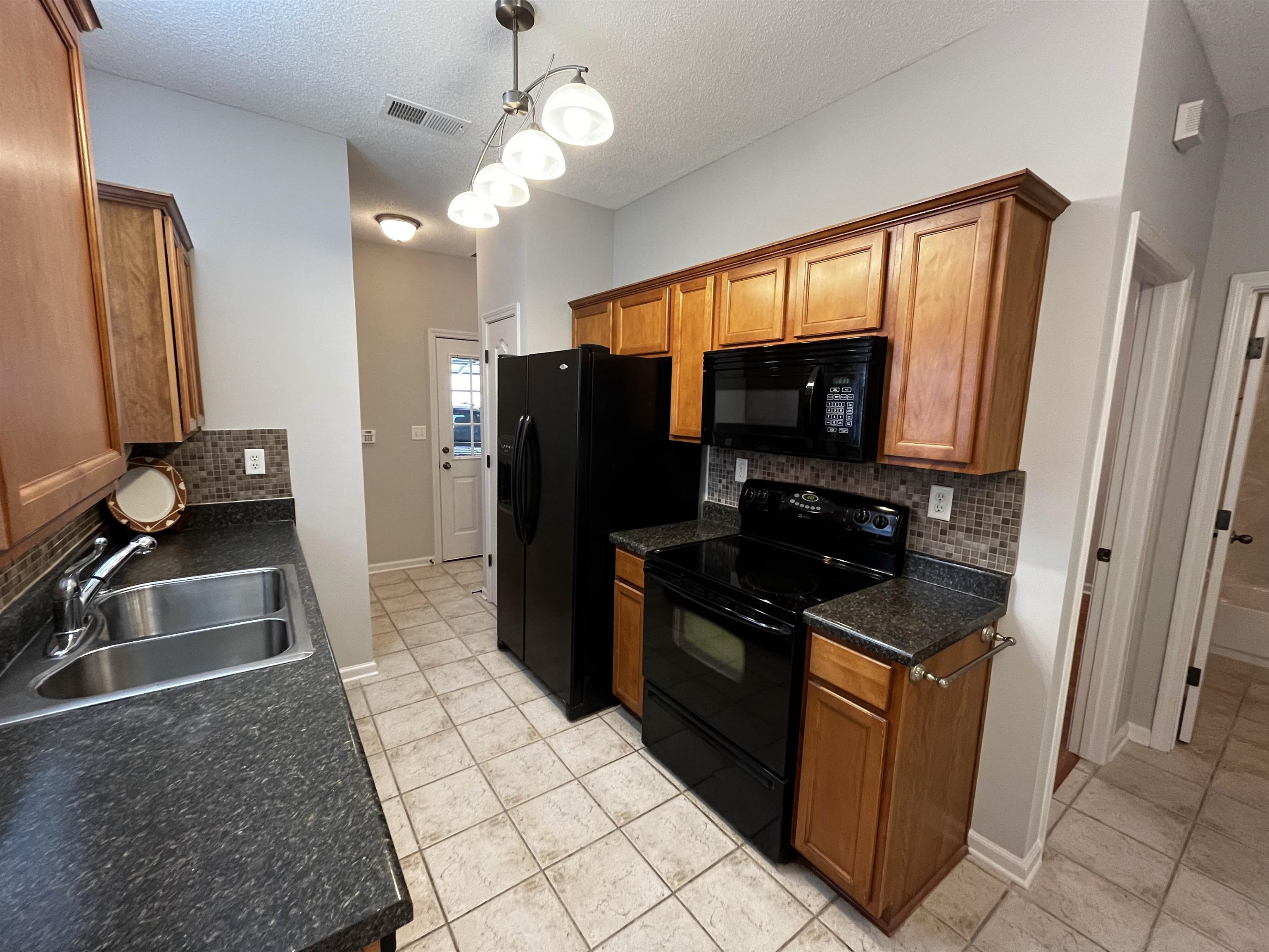 1182 Collierville Arlington Road Collierville, TN 38017 - Photo 13 of 34 a kitchen with stainless steel appliances granite countertop a refrigerator and a sink